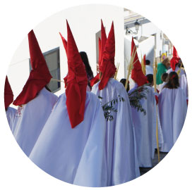 Cofrades, penitentes que desﬁlan, cada cofradía con sus colores.